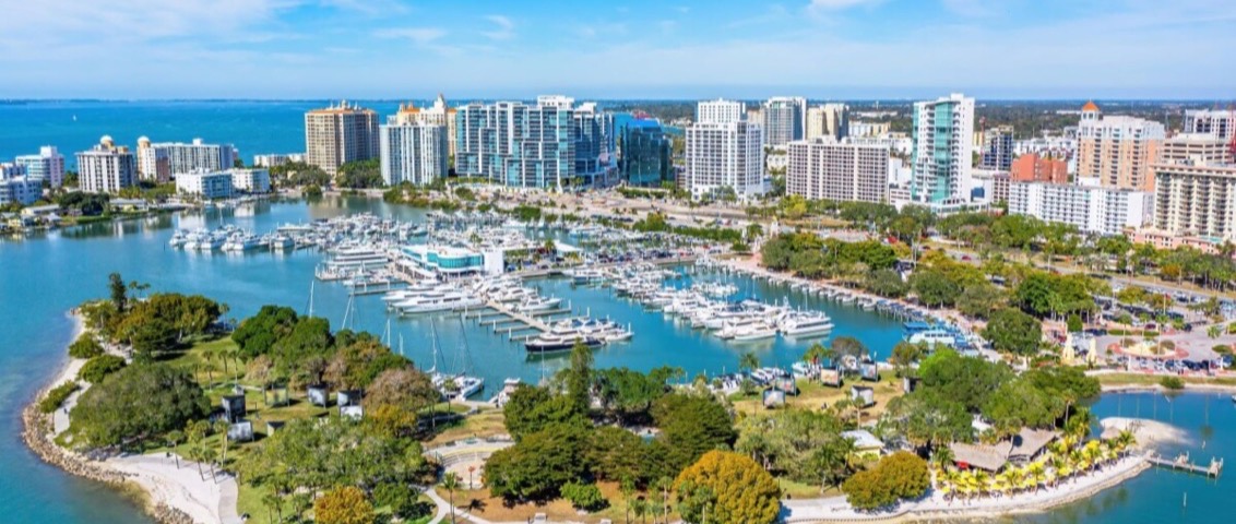 Aerial view of the Sarasota bayfront — the marina, Bayfront Park, and the downtown skyline